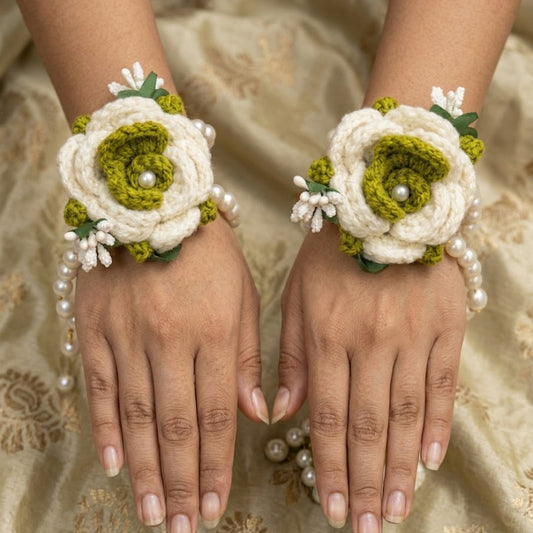 Hands wearing floral wrist corsages on a patterned fabric background
