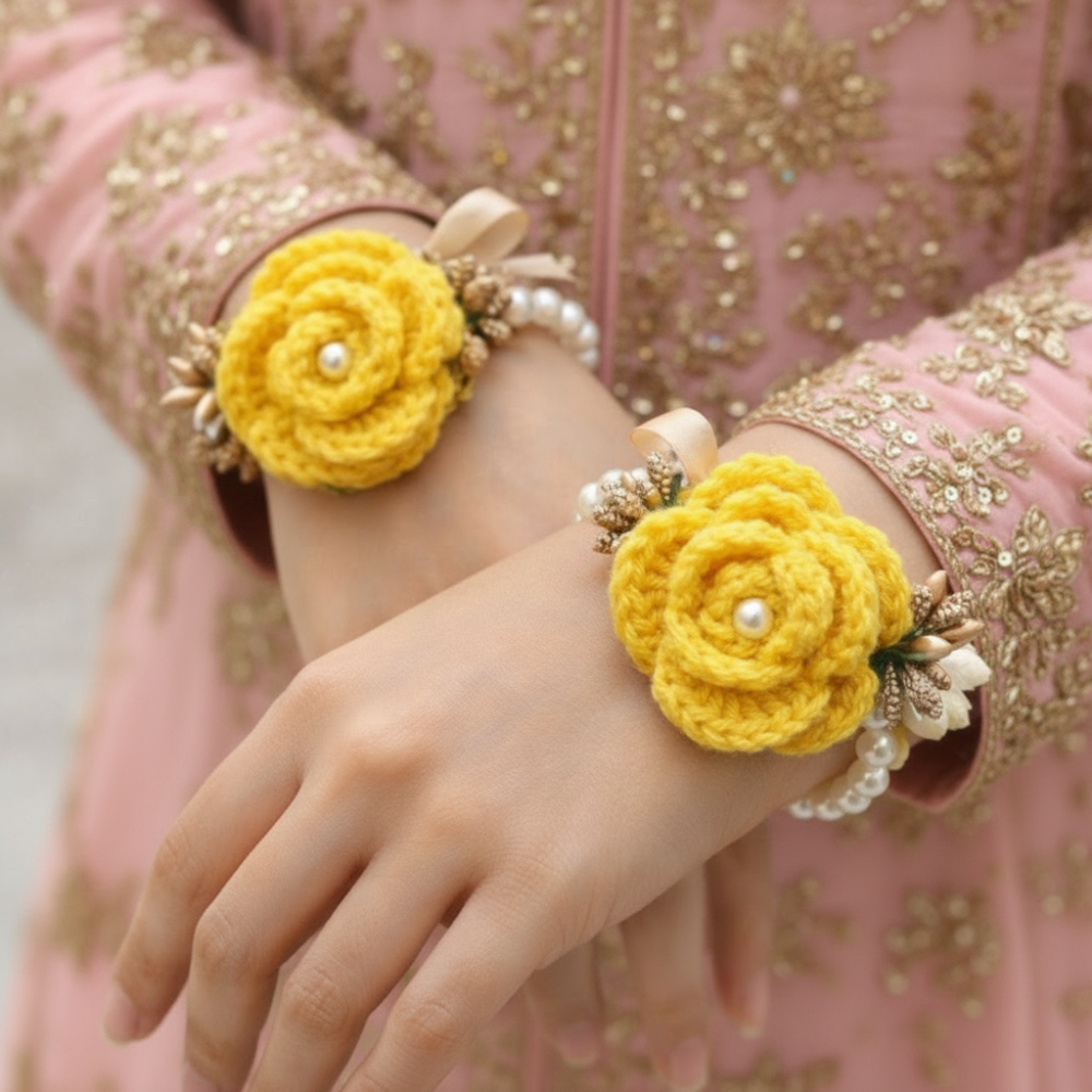Yellow flower wristbands on a person wearing a patterned garment.